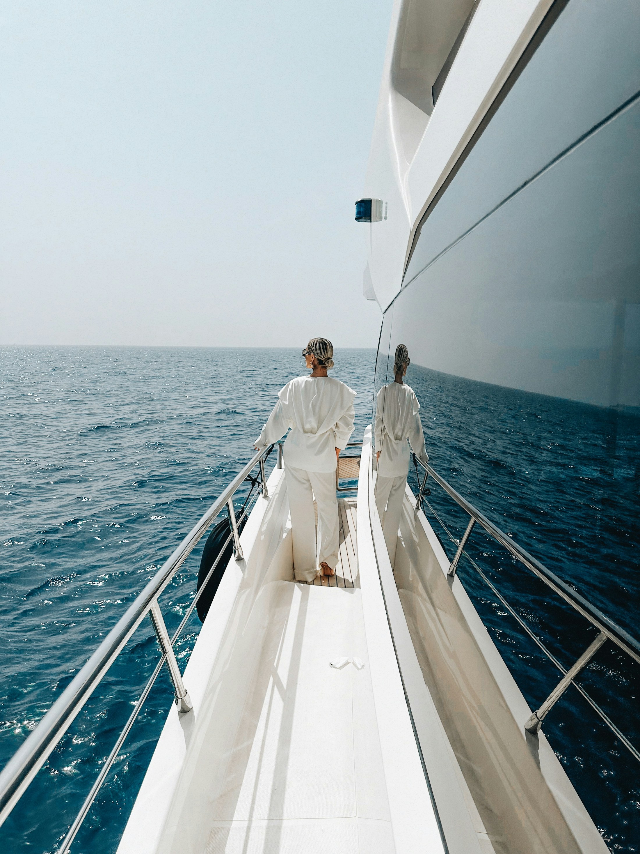 Two guests walking along the bow of a private yacht